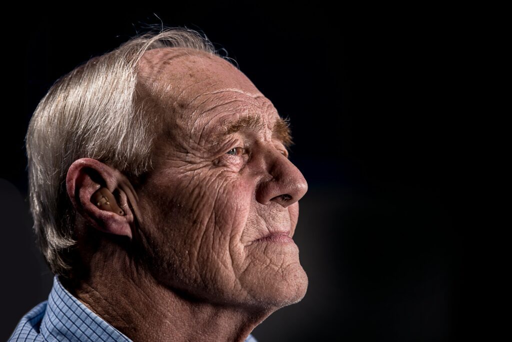 An older man gazing into the distance, lost in memories